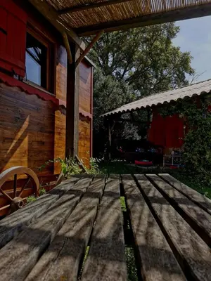 a wooden table in front of a house at Le nid des crinières vagabondes in Oletta