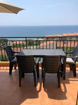a table and chairs on a balcony with the ocean at Location corsica in Ajaccio