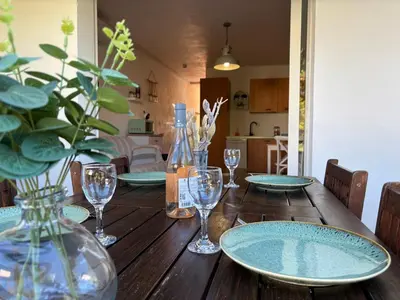 a wooden table with plates and wine glasses on it at Amikad'o in San-Nicolao