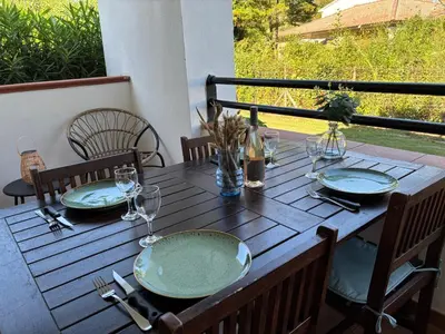 a wooden table with plates and wine glasses on it at Amikad'o in San-Nicolao