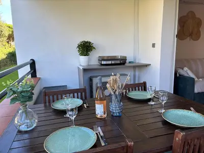 a wooden table with plates and wine glasses on it at Amikad'o in San-Nicolao