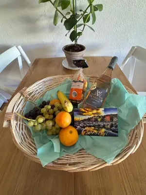 a basket of fruit and a bottle of wine on a table at Amikad'o in San-Nicolao