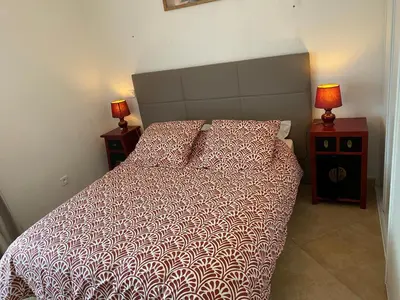 a bedroom with a bed and two night stands with lamps at Villa CORSE in Solaro