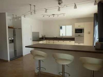 a kitchen with a counter and stools in it at Villa CORSE in Solaro