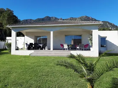 a house with a table and chairs in a yard at Villa en Corse sur la Côte Est in Santa-Maria-Poggio