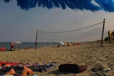 a beach with a volleyball net and people on it at Villa en Corse sur la Côte Est in Santa-Maria-Poggio