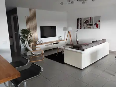 a living room with a white couch and a tv at Villa en Corse sur la Côte Est in Santa-Maria-Poggio
