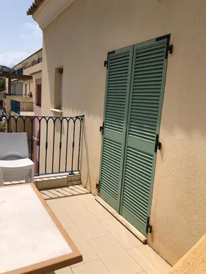a green door on the side of a building at Appartement T2 vue mer sur le port de Solenzara in Kamiesch