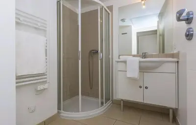 a bathroom with a glass shower and a sink at Appartement T2 vue mer sur le port de Solenzara in Kamiesch