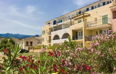 a building with flowers in front of it at Appartement T2 vue mer sur le port de Solenzara in Kamiesch