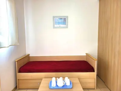 a room with a bed with two pairs of shoes at Appartement T2 vue mer sur le port de Solenzara in Kamiesch