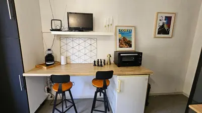 a small kitchen with a counter with two stools at Studio Gare Corte in Corte