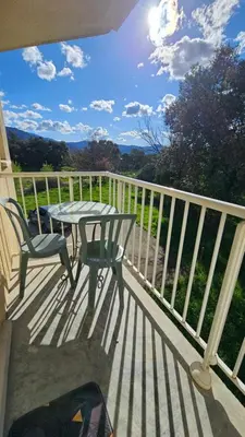 a deck with a table and chairs on a balcony at Studio Gare Corte in Corte