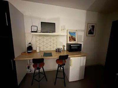 a room with a desk with a computer and two bar stools at Studio Gare Corte in Corte