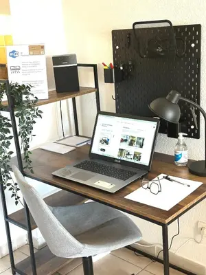 a laptop computer sitting on a desk with a chair at CASA LOUNA 2 Pièces à 150 m de la plage et du centre vile in Sari Solenzara