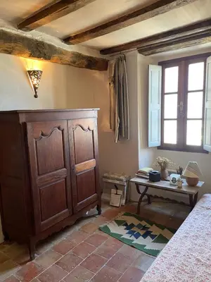 a bedroom with a wooden cabinet and a table at Maison de village 3 chambres 2 SDB avec terrasse & jardin - Proche St Florent in Pieve