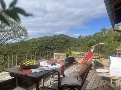 a table and chairs on a deck with a view of a mountain at Maison de village 3 chambres 2 SDB avec terrasse & jardin - Proche St Florent in Pieve