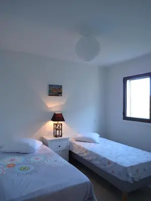 a bedroom with two beds and a window at Appartement Cité Du Sel in Porto-Vecchio