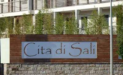 a sign for a hotel on a brick wall at Appartement Cité Du Sel in Porto-Vecchio