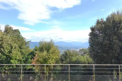a view of the mountains from behind a fence at Apartment 3 rooms with garden in Ajaccio in Ajaccio