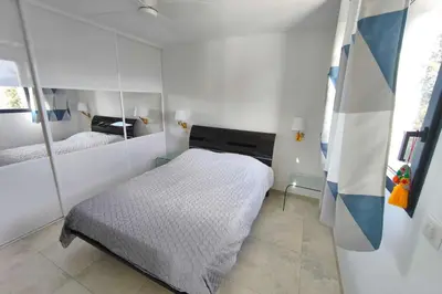 a small bedroom with a bed and a mirror at Apartment 3 rooms with garden in Ajaccio in Ajaccio