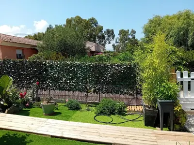 a garden with a hedge and a fence at Villa de luxe en bord de mer Résidence Torra Mare a Prunete in Cervione