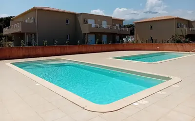 an image of a swimming pool in front of some houses at Villa de luxe en bord de mer Résidence Torra Mare a Prunete in Cervione