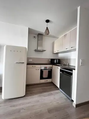 a kitchen with a white refrigerator in a room at Appartement plus place de parking en sous sol privatif in Ajaccio
