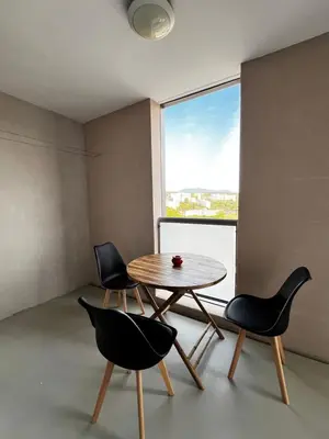 a table and chairs in a room with a window at Appartement plus place de parking en sous sol privatif in Ajaccio
