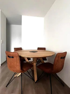 a wooden table with four chairs around it at Appartement plus place de parking en sous sol privatif in Ajaccio