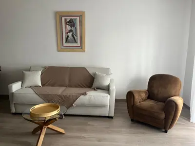 a living room with a couch and a chair at Appartement plus place de parking en sous sol privatif in Ajaccio