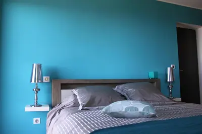 a blue bedroom with a bed with a blue wall at Villa Petrera in Valle-di-Campoloro