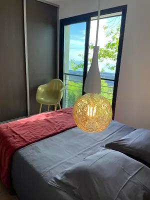 a bedroom with a bed with a lamp and a chair at Villa Petrera in Valle-di-Campoloro