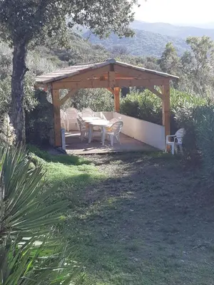 a wooden pavilion with a table and chairs under it at I Casetti in Molini