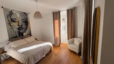 a bedroom with a bed and a chair at ALG appartement in Corte