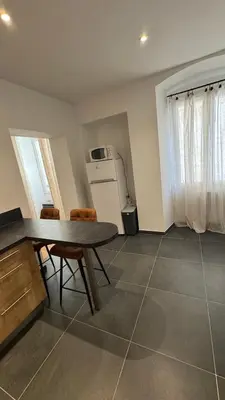 a kitchen with a table and chairs in a room at ALG appartement in Corte