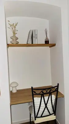 a desk with a chair and books on a wall at ALG appartement in Corte