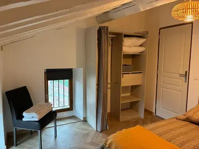 a bedroom with a bed and a chair and a window at Appartement Sainte Lucie de Tallano,2 personnes au centre du village in Santa-Lucia-di-Tallano