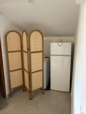 a kitchen with three wooden shelves next to a refrigerator at Appartement Sainte Lucie de Tallano,2 personnes au centre du village in Santa-Lucia-di-Tallano