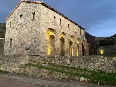 an old stone building with arches and a stone wall at Appartement Sainte Lucie de Tallano,2 personnes au centre du village in Santa-Lucia-di-Tallano