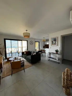 a living room with a couch and a table at Bel appartement T3 vue mer 5 min des plages à pied in Propriano