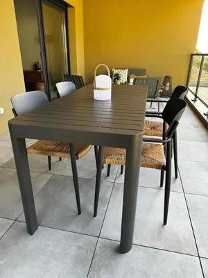 a brown table with chairs and a basket on top at Bel appartement T3 vue mer 5 min des plages à pied in Propriano