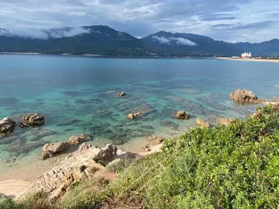 a view of a beach with rocks and the water at Bel appartement T3 vue mer 5 min des plages à pied in Propriano