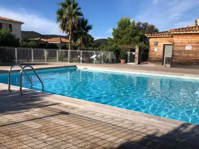 a swimming pool with blue water in a yard at un gout de paradis in Zonza