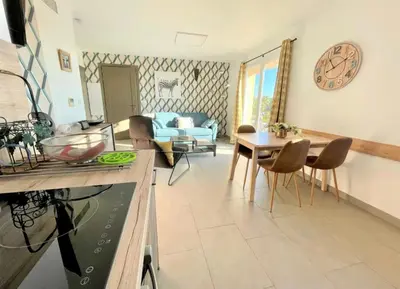 a living room with a blue couch and a table at un gout de paradis in Zonza