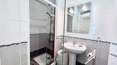 a bathroom with a sink and a glass shower at Casamea - Vue Mer, Clim & Parking, Proche Plage in Ajaccio