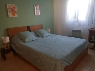 a bedroom with a bed with blue sheets and two pillows at Mini villa T2, 200 m de la plage, piscine chauffée, jardin in Prunete