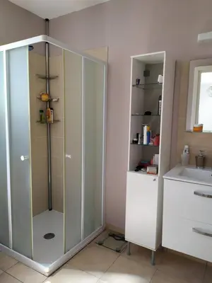 a bathroom with a glass shower and a sink at Mini villa T2, 200 m de la plage, piscine chauffée, jardin in Prunete