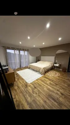 a large bedroom with a bed and a wooden floor at Magnifique Villa avec piscine et jacuzzi in Alata