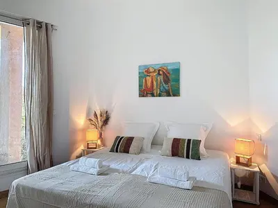 a bedroom with a white bed with two lamps at Villa Mimosa 150 m from Pinarello Beach in Zonza